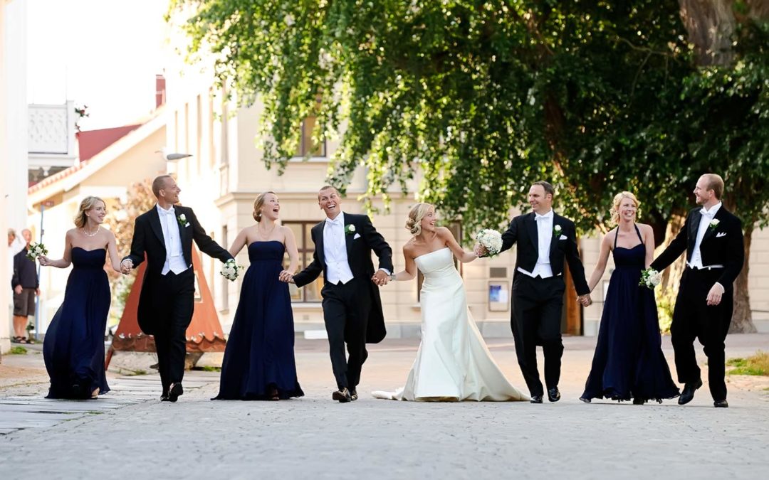 Maria och Martin från Stockholm hade sitt bröllop på Marstrand och här har Stig Albansson fotograferat dem med deras brudfölje i riktning mot kyrkan med Silverpoppeln skymtandes i bakgrunden. Trädet som är Kungälv kommuns största träd.